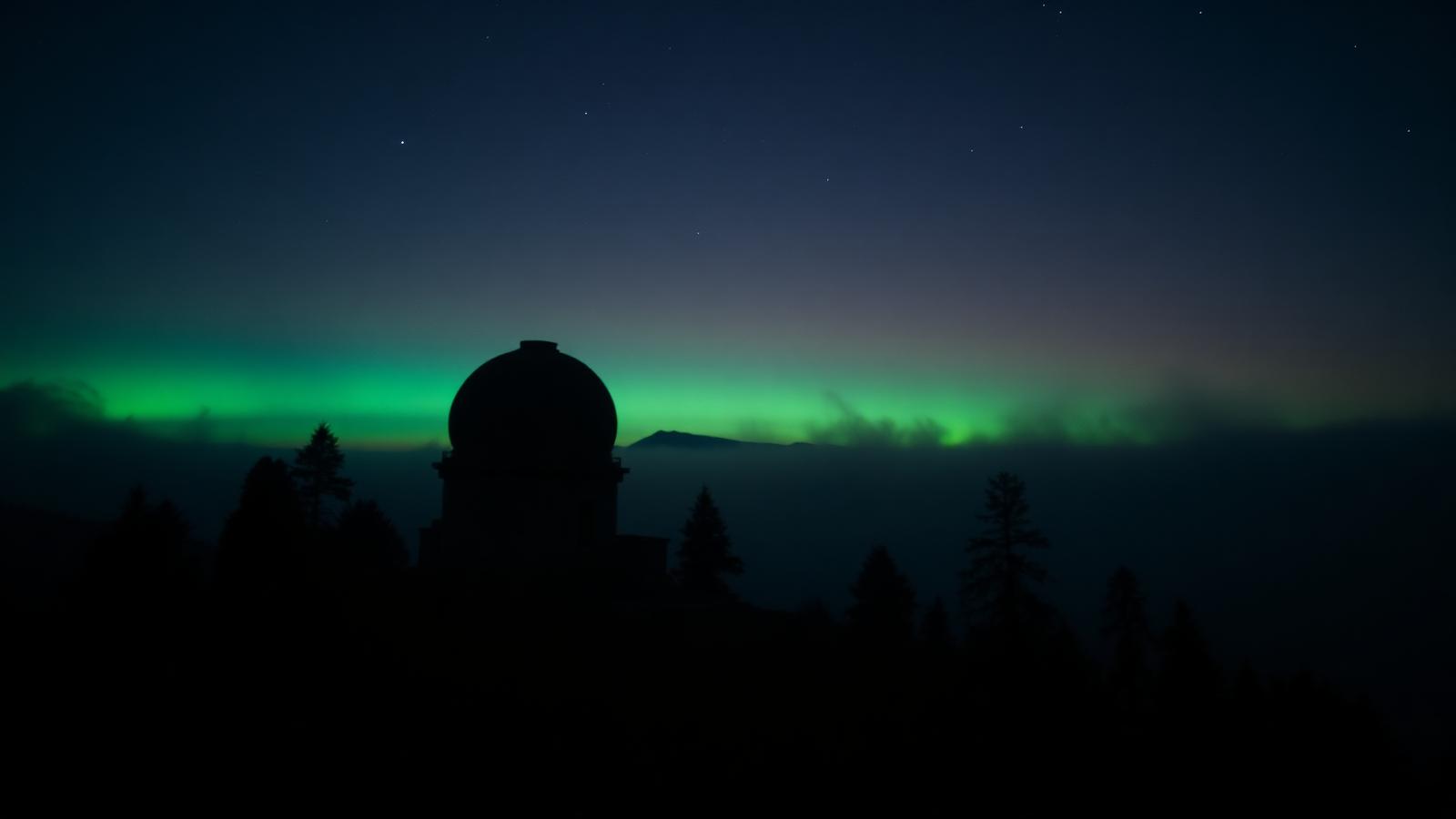 Observatory dome beneath an aurora, evoking long-horizon research